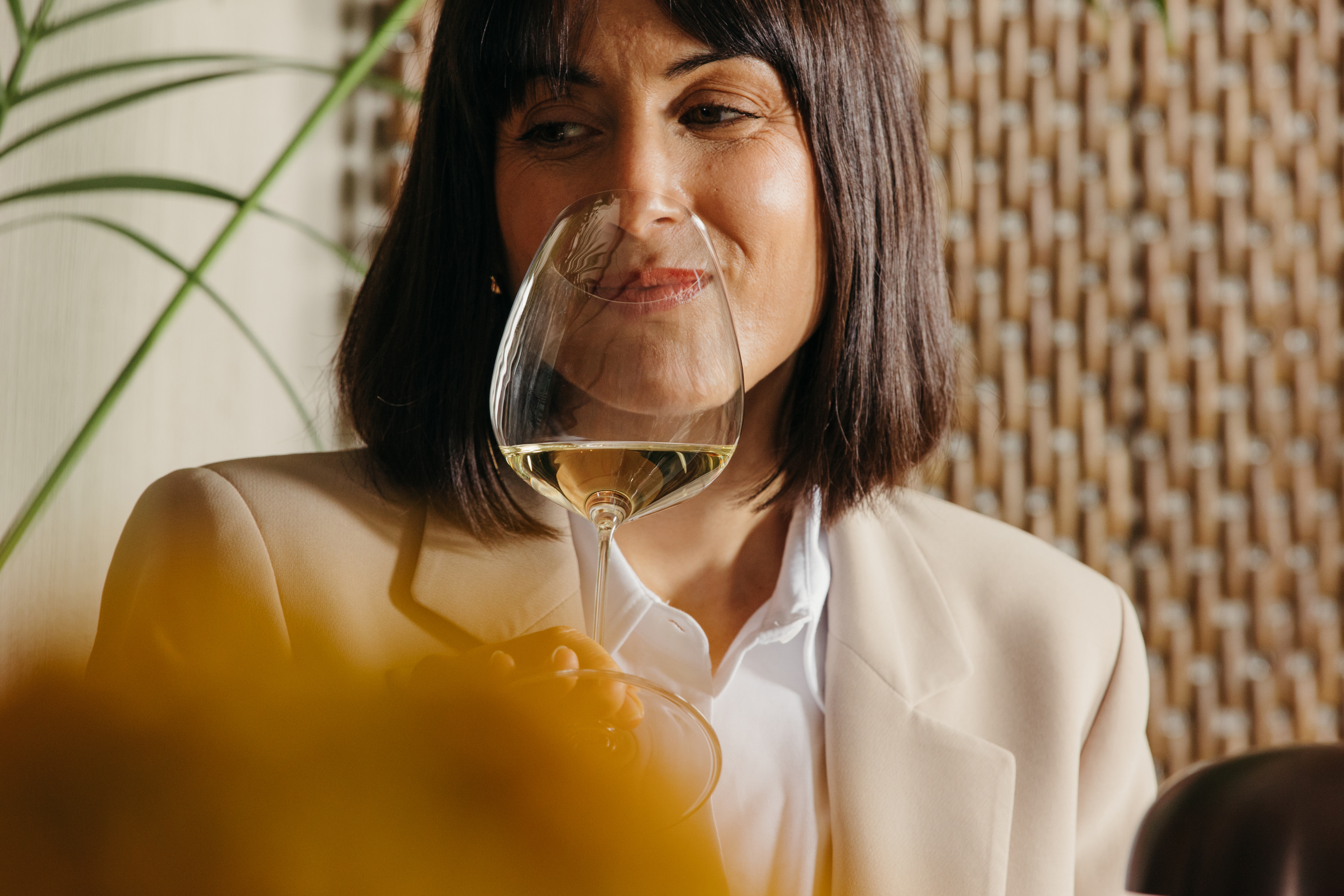 Chica bebiendo una copa de vino blanco en un restaurante
