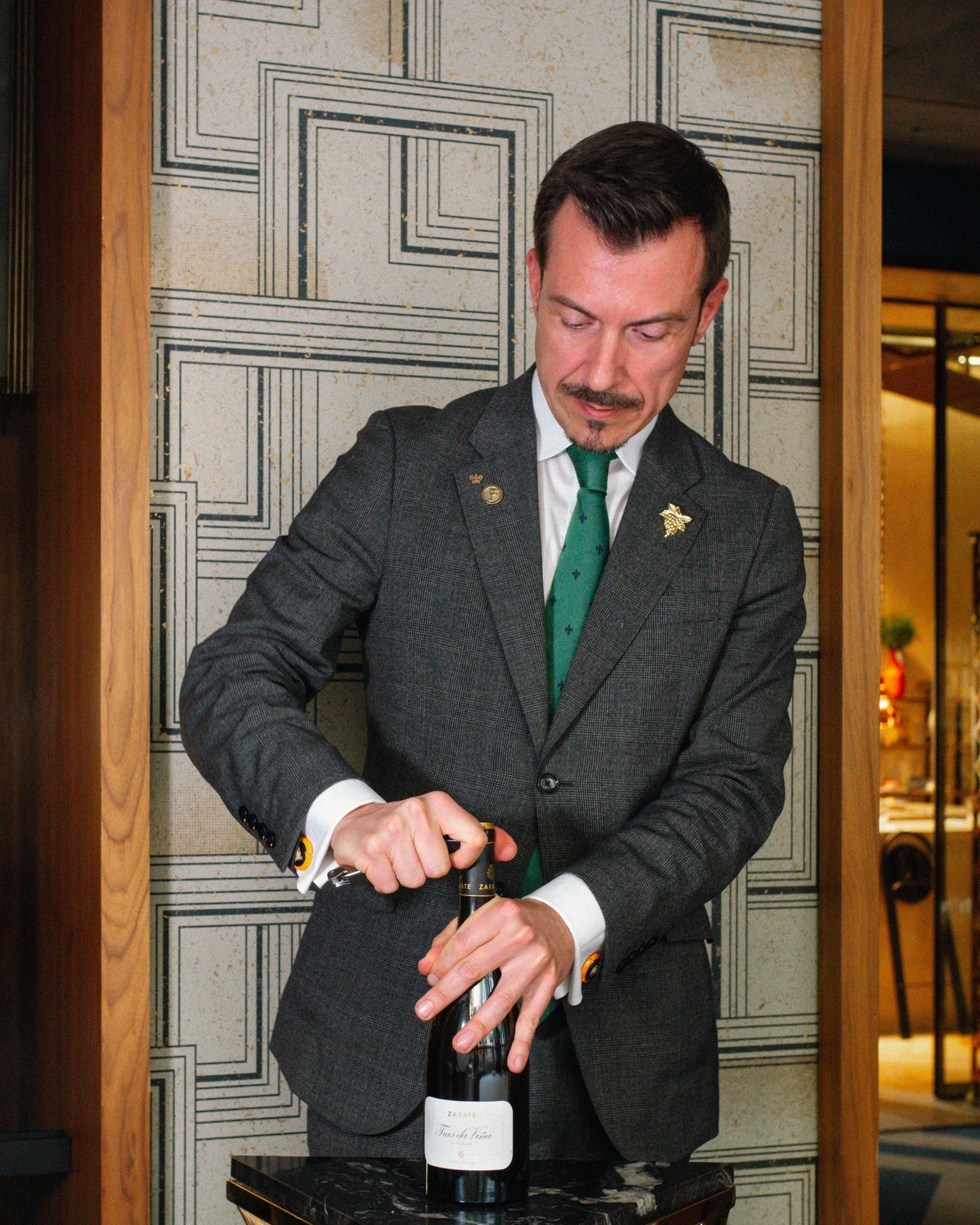 Sumiller Alejandro Rodríguez descorchando una botella de vino.